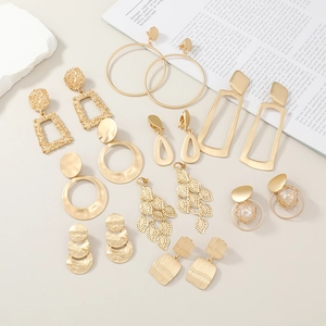 Set of 9 gold geometric alloy earrings including hoops and pearls on aesthetic background