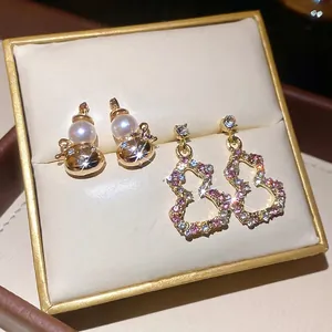 Gourd pearl earrings and colorful zircon drop earrings on a premium jewelry display