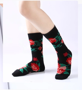 Dettaglio di calze con ricamo floreale di rose rosse su tessuto misto cotone nero