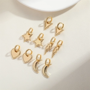 Détail de dix boucles d'oreilles dorées en formes d'étoile, de cœur, de lune et d'éclair