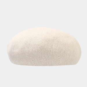Close-up of beige knitted beret showing thick textured rabbit hair wool fabric