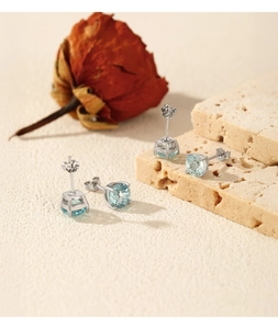 Detail of S925 silver stud earrings with light blue round stones and four-prong setting