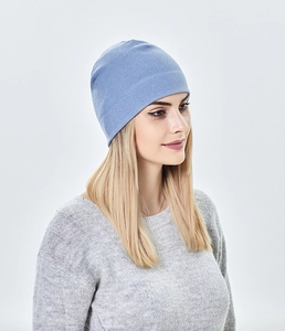 Detail showing soft knitted texture of a light blue winter beanie on a blonde female model