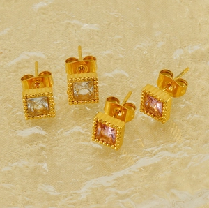 Detail of square gold plated titanium steel earrings with clear and pink zircon stones