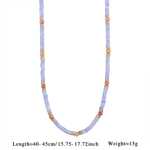 Detail shot of beaded necklace with light blue stones, pink beads, and gold spacers