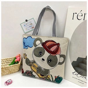 Detail of cute panda print on beige canvas tote bag with striped handles and tulips