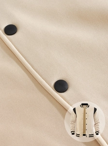 Macro detail of high-quality fabric and contrasting snap buttons on varsity jacket