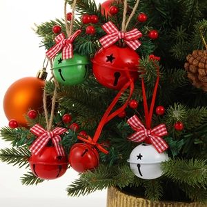 Close-up of red, green and white Christmas bells with plaid ribbons and red berries