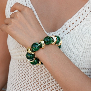 Detail of bohemian bracelet with green marble beads and gold metallic accents on wrist