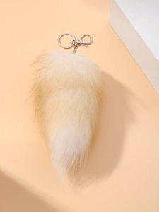 Detailed macro view of the fluffy faux fox tail keychain with a silver lobster clasp