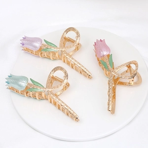 Detailed view of three tulip-shaped metal hair claws with pearl glaze in pastel colors