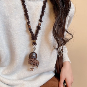 Détail du pendentif cœur en peluche léopard vintage avec clous métalliques sur chaîne