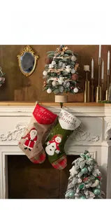 Detail of Christmas stockings with Santa and Snowman embroidery on a fireplace mantel