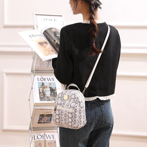 Close-up of white textured tweed mini backpack with elegant gold-tone metal hardware