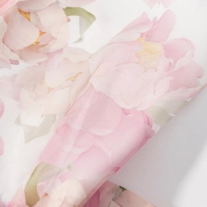 Nahaufnahme von rosa floralem Chiffonstoff mit feiner Textur und transparentem Detail