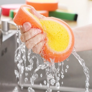 Absorbent fruit sponge scouring pad in orange showing water droplets and high elasticity