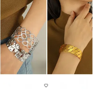 Detailed view of hollow oval and scale texture on silver and gold wide cuff bracelets