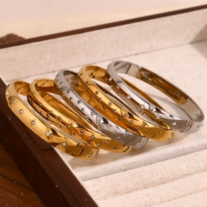 Macro view of gold and silver star and moon embossed bangles with white crystals