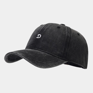 Detail of a black washed denim baseball cap with white embroidered D letter on the front