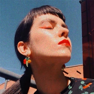Three-color cherry pendant earrings in 18K gold plated copper on model with sky background