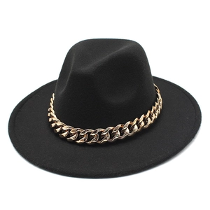 Detailed texture of black felt fedora hat with a bold decorative gold chain accent