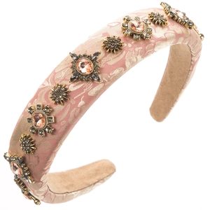 Dettaglio del cerchietto barocco in spugna rosa con jacquard dorato e strass scintillanti