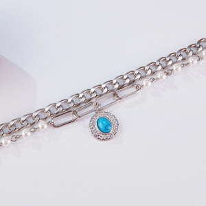 Detail of silver layered bracelet with pearls and turquoise stone round pendant
