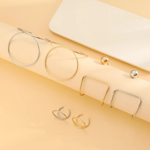 Vue détaillée de boucles d'oreilles géométriques dorées et argentées sur un support
