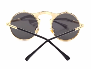 Macro detail of steampunk flip-up sunglasses showing golden metal hinges and round lenses