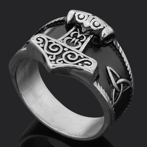 Detail of vintage silver Viking Mjolnir ring featuring Celtic knot relief on black surface