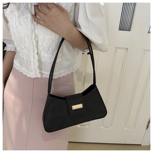 Close-up of a black faux leather shoulder bag with a stylish gold rectangular metal buckle