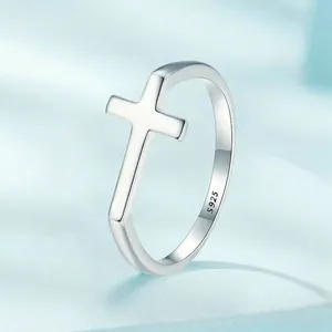 S925 sterling silver minimalist cross ring for women on light blue silk background
