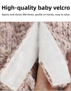 Detail of durable white hook and loop fastener on pink knitted baby doll clothes