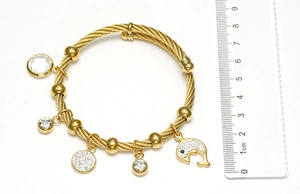 Close-up of 18K gold-plated steel wire bracelet with dolphin and crystal charms