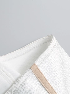 Détail du tissu jacquard argenté métallique avec bande de silicone antidérapante sur le corsage