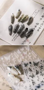 Close-up of 3D butterfly nail stickers and ink-wash gradient press-on nails on paper