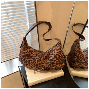 Detail of leopard print crescent bag on a book with soft mirror reflection lighting