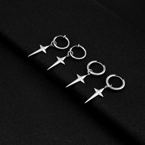 Detailed macro shot of silver stainless steel star earrings on a dark matte background