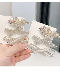 Macro detail of bow-shaped hair clips with sparkling crystals and white pearls