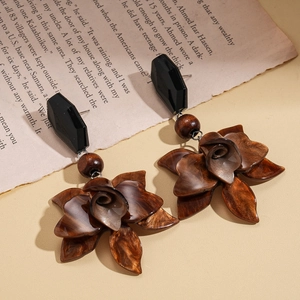 Boucles d'oreilles rétro en résine marron texture bois sur fond de livre vintage