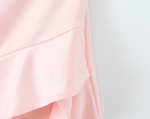 Close-up of pink irregular ruffle dress showing fabric texture and fine stitching detail