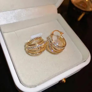 Boucles d'oreilles créoles dorées avec cristaux et perle dans un écrin de luxe