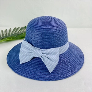 Detail of navy straw sun hat featuring light blue striped bow ribbon for beach vacation