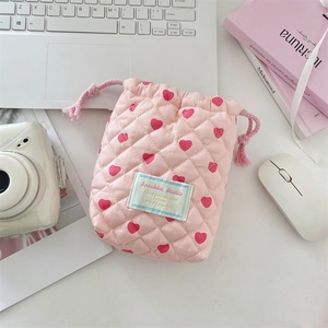 Detail of pink quilted drawstring bag with red hearts and soft cotton padding