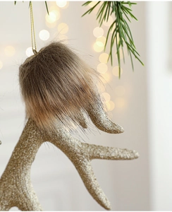 Close-up of gold glitter reindeer antlers with faux fur for Christmas tree decoration