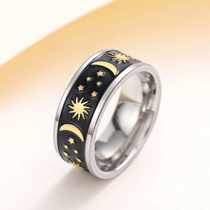 Macro shot of silver wide band ring with celestial sun moon and star pattern engraving