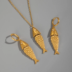 Detail of gold fish-shaped necklace and earrings set with delicate sparkling crystals