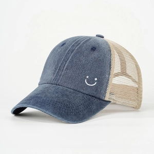 Detail of blue denim baseball cap with beige mesh back and side smiley embroidery