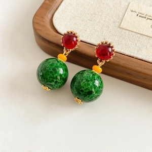 Détail de boucles d'oreilles vintage en céramique avec perles rouges, jaunes et vertes