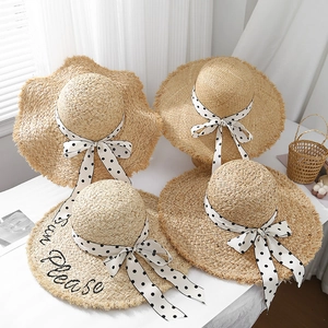 Detail of raffia sun hats with polka dot ribbons and Sun Please embroidery